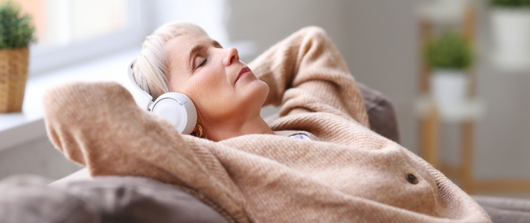 Elderly woman listening to voiced script while relaxing